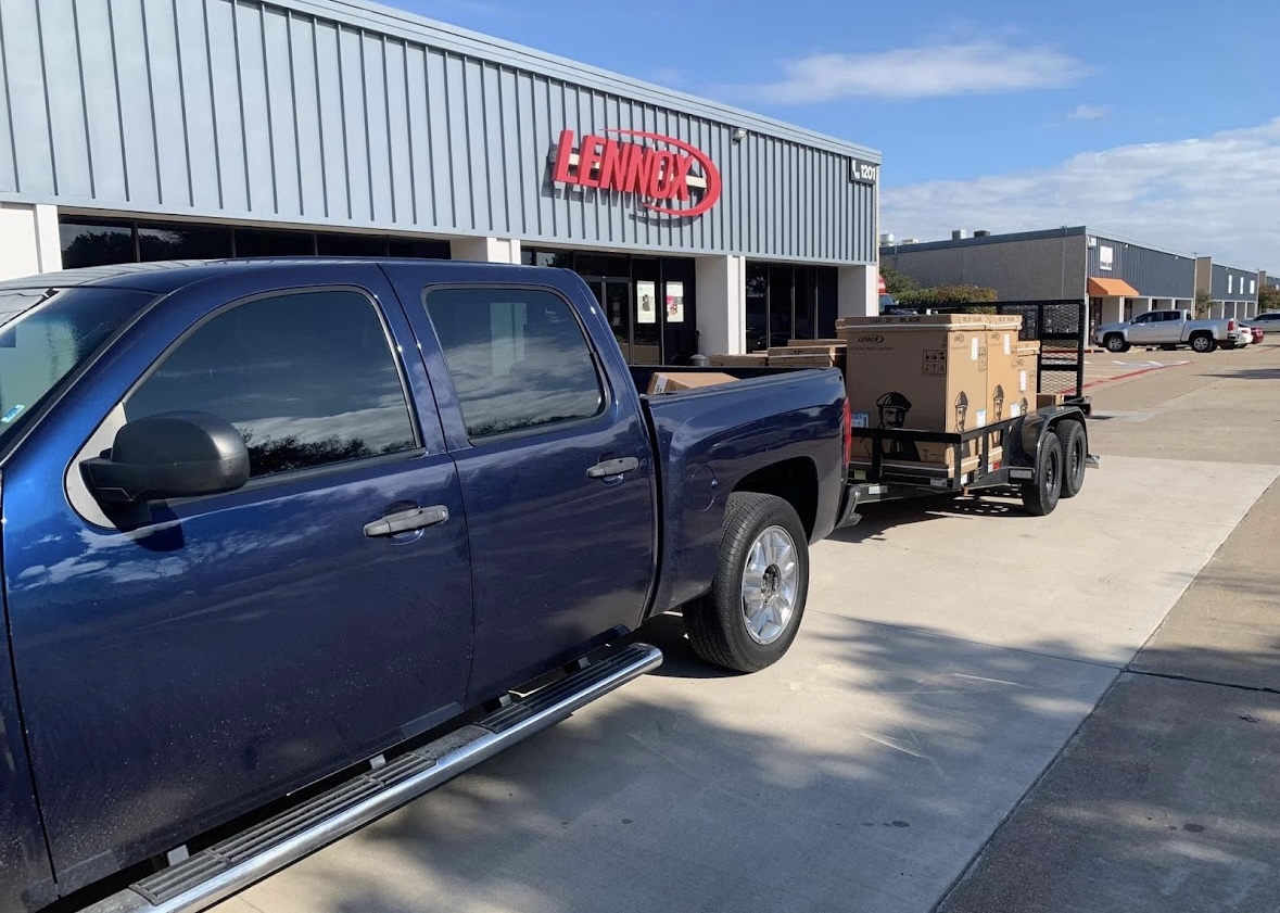 Truck and trailer picking up new Lennox HVAC equipment at a supply house