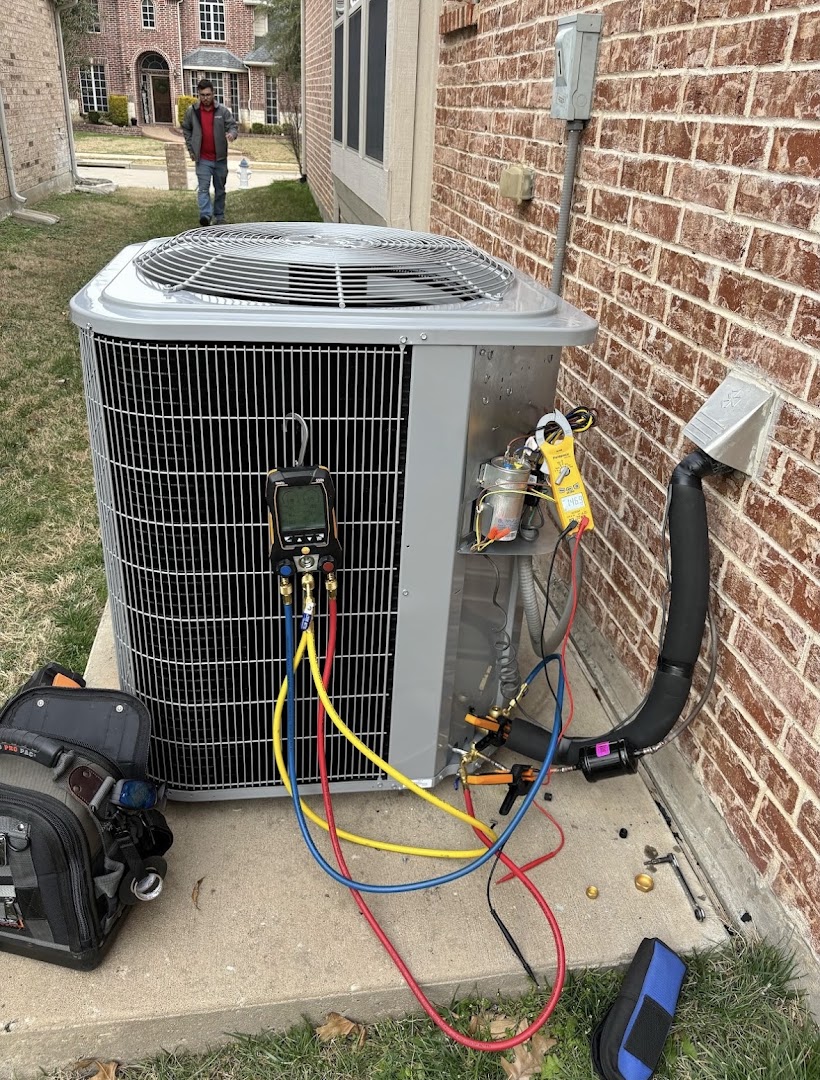 HVAC technician servicing a residential air conditioning unit with diagnostic gauges connected